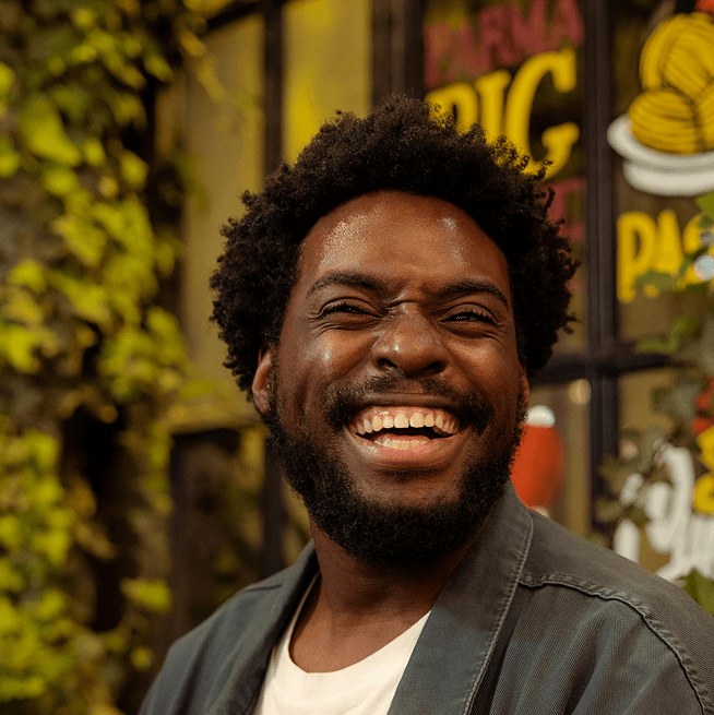 Close-up, circular photo of a young man with a warm smile, short dark curly hair, and a dark beard, looking directly at the viewer. Close-up, circular photo of a young man with a warm smile, short dark curly hair, and a dark beard, looking directly at the viewer.